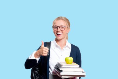 Mutlu genç öğrenci kız kitap, lise ya da üniversite graduand mavi arka plan üzerinde tutarak. Okula dönüş