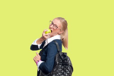 Mutlu genç öğrenci kız kitap, lise ya da üniversite graduand sarı arka plan üzerinde tutarak. Okula dönüş