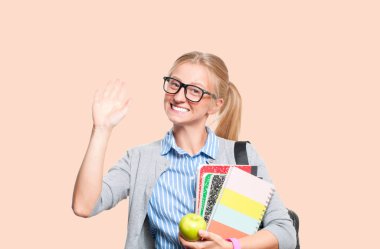 Mutlu genç öğrenci kız kitap, lise ya da üniversite graduand pastel arka plan üzerinde tutarak. Okula dönüş