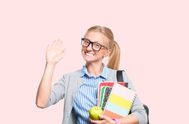 Mutlu genç öğrenci kız kitap, lise ya da üniversite graduand pembe arka plan üzerinde tutarak. Okula dönüş