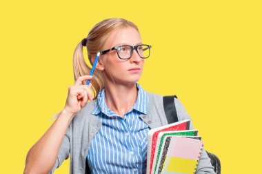 Mutlu genç öğrenci kız kitap, lise ya da üniversite graduand sarı arka plan üzerinde tutarak. Okula dönüş