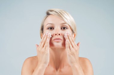 Köpük yıkama yüzünde mutlu bir kadın. Mükemmel temiz cilt kavramı. Güzellik ve spa