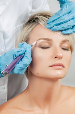 Microblading kaşlar. Kalıcı makyaj yapma güzellik uzmanı. Çekici kadın Yüz Bakımı güzellik salonunda Başlarken