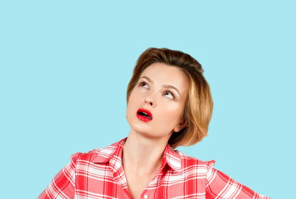 青の背景に見上げる表情に疑問を持つ若い思考ビジネス女性 — ストック写真