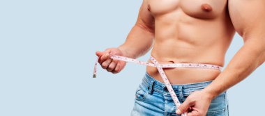 Kusursuz bir beden beline mavi arka plan üzerinde ölçüm ile kas adam.