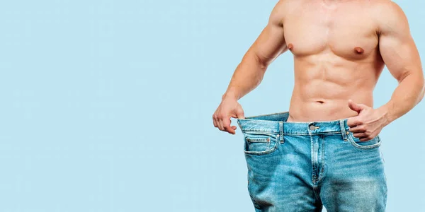 男子穿着大牛仔裤后饮食 在蓝色背景的减肥概念 — 图库照片