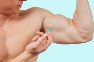 Steroid enjeksiyonu kol mavi zemin üzerine alarak vücut geliştirmeci. 
