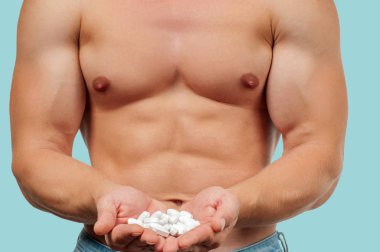 Adam vücut geliştirmeci steroid tablet şeklinde pastel arka plan üzerinde