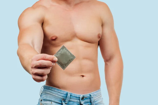 Conceito Sexual Segurança Bonito Homem Musculoso Com Preservativo Fundo Azul — Fotografia de Stock