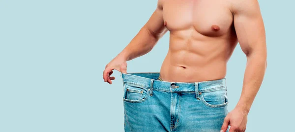男子穿着大牛仔裤后饮食 在蓝色背景的减肥概念 — 图库照片