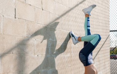 Sağlıklı yaşam tarzı ve yoga kavramları. Spor giyim kadında fitness egzersiz yaparak, duvardaki esniyor