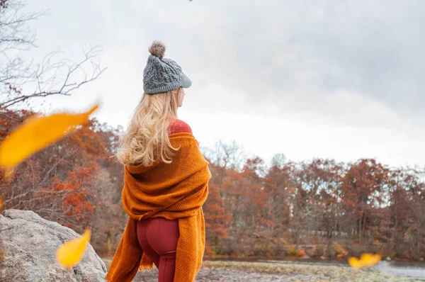 在温暖的帽子和秋天的衣服的女人旅行者看着惊人的湖泊和森林 流浪欲望旅行的概念 — 图库照片