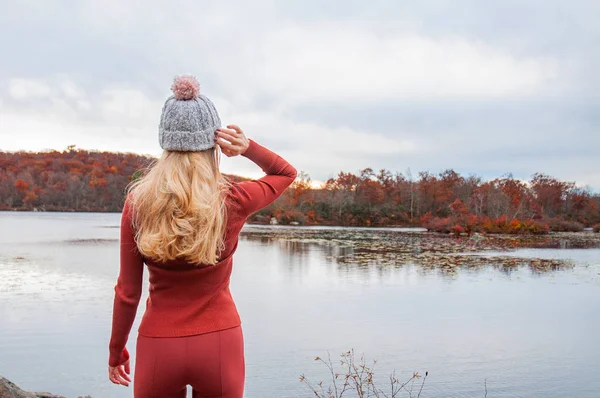 暖かい帽子 素晴らしい湖と森 放浪旅行の概念を見て秋の服で女性旅行者 — ストック写真