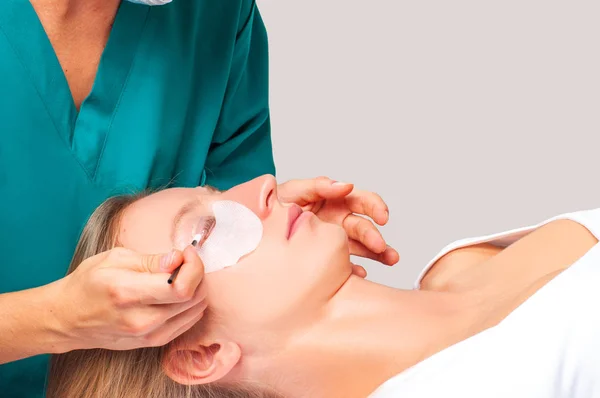 Eyelash care treatment procedures. Woman doing eyelashes lamination, staining, curling, laminating and extension for lashes.