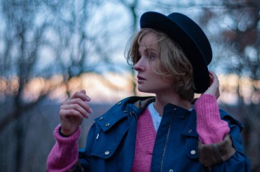 Şapka ve sıcak sonbahar giysileri sonbahar ormandaki güzel kadın