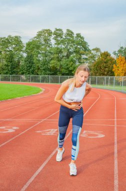 Koşu parkuru atletik kadın yan krampları egzersiz sırasında vardır