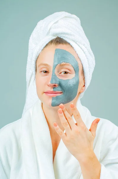 Spa Clay Mask. Beautiful young woman with clay facial mask. Skincare and beauty Concept.