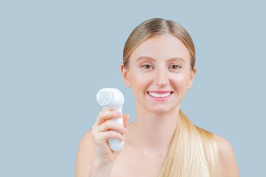 Güzel kadın yüz cildi fırça ile yıkıyor. Yüz güzelliği tedavi kavramı.