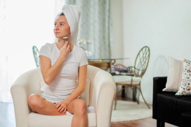 Yüz masaj. Güzel kadın silindir kullanarak masaj yüz almak 