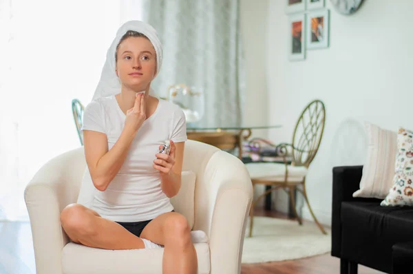 Mooie vrouw verwijderen van make-up uit haar gezicht thuis — Stockfoto