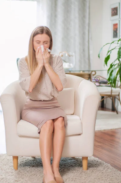 Sick woman with paper napkin sneezing, experiences allergy symptoms — Stock Photo, Image