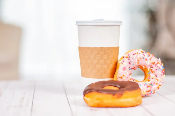 Copa de café y donut de chocolate en la mesa de madera . — Foto de Stock