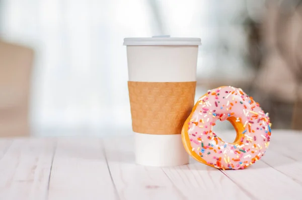 Tasse Kaffee und Donut aus Schokolade auf Holztisch. — Stockfoto