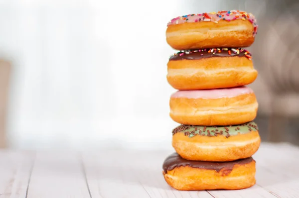 Bunt glasierte Donuts auf Holztisch. — Stockfoto
