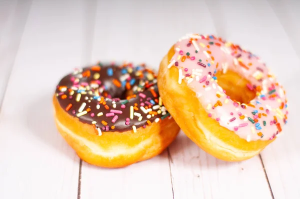 Donuts glacés colorés sur table en bois . — Photo