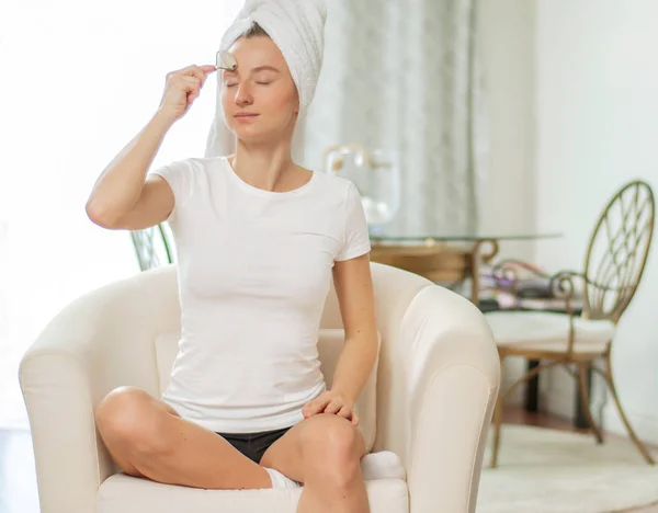 Masaje facial. hermosa mujer consiguiendo masaje cara usando rodillo masajeador en casa — Foto de Stock