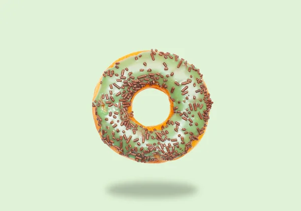 Rosquilla verde sobre fondo verde pastel . —  Fotos de Stock