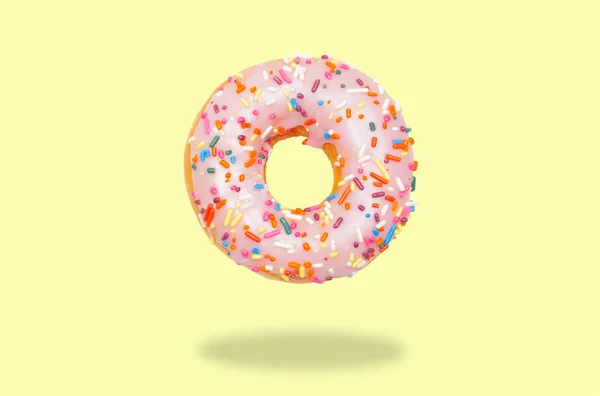 Pink donut on on pastel yellow background. — Stock Photo, Image