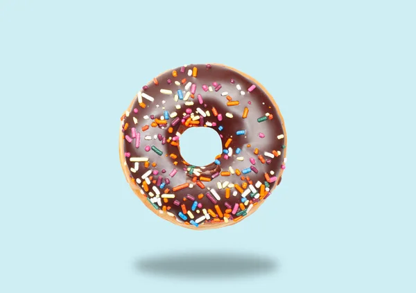 Donut de chocolate no fundo azul pastel . — Fotografia de Stock