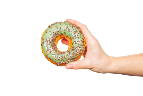 Mão feminina segurando donut colorido no fundo branco pastel — Fotografia de Stock