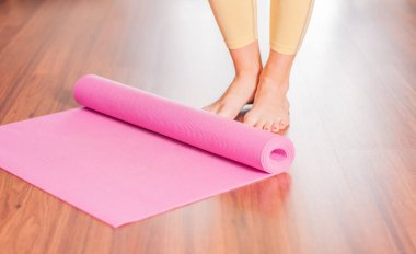 Evde egzersiz sonrası yoga veya fitness mat katlanır Çekici genç kadın
