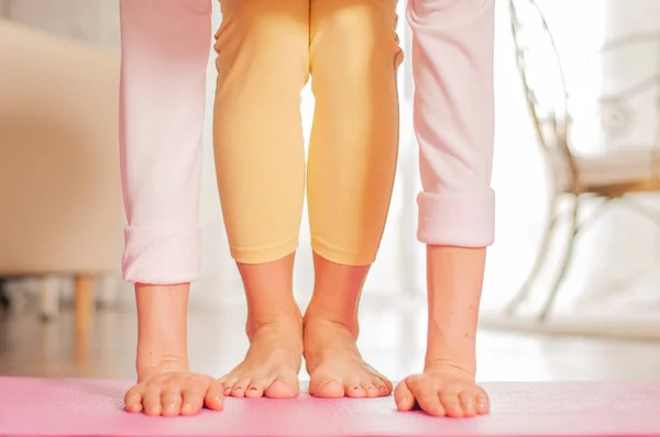 Жіночі ноги і руки. Жінка робить йогу на фітнес килимку вдома . — стокове фото