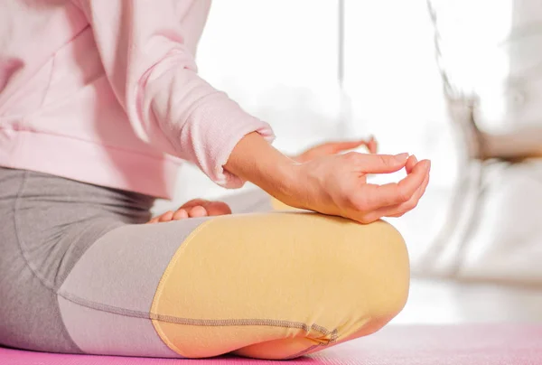 Медитація. Жінка практикує йогу, сидячи в позі лотоса вдома . — стокове фото