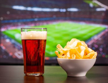 Tv önünde bira bardakları ve cips, evde futbol