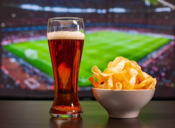 Copos de cerveja e batatas fritas na frente da tv, futebol em casa — Fotografia de Stock