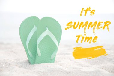 Beyaz kumlu sahilde parmak arası terlik. Yaz arka planı 