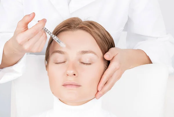 La mujer está recibiendo la inyección. Tratamiento antienvejecimiento y lifting facial. Inyección de lifting facial de la piel en la cara de la mujer . — Foto de Stock