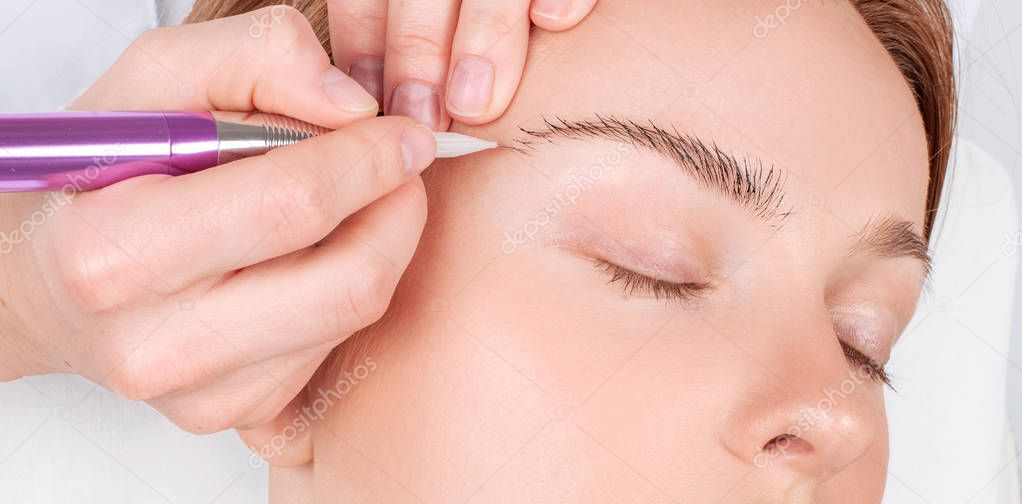 Microblading eyebrows. Attractive woman getting facial care and permanent makeup. 
