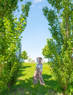 Aksesuarları bir sürü güzel boho tarzı kadın ve tulum parkta yaz saati zevk.