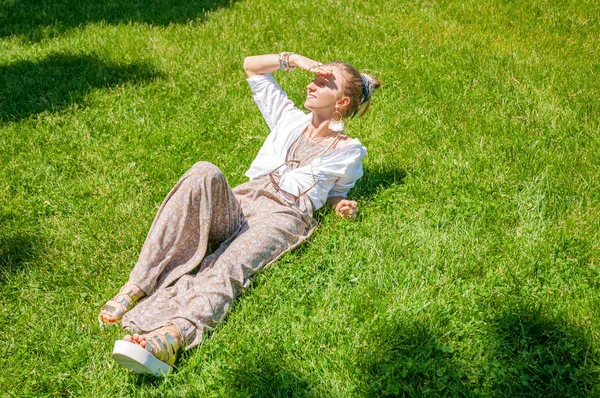 Fata frumoasă întinsă pe iarbă verde și zâmbește se bucură de o zi însorită în parc. Conceptul de vară — Fotografie, imagine de stoc