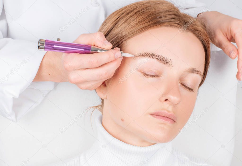 Microblading eyebrows. Attractive woman getting facial care and permanent makeup. 