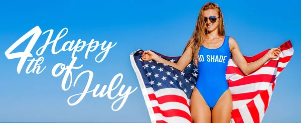 USA függetlenség napja. Egyesült Államok ünnepelni ünnep július 4. Boldog nő gazdaság amerikai zászló a strandon. — Stock Fotó