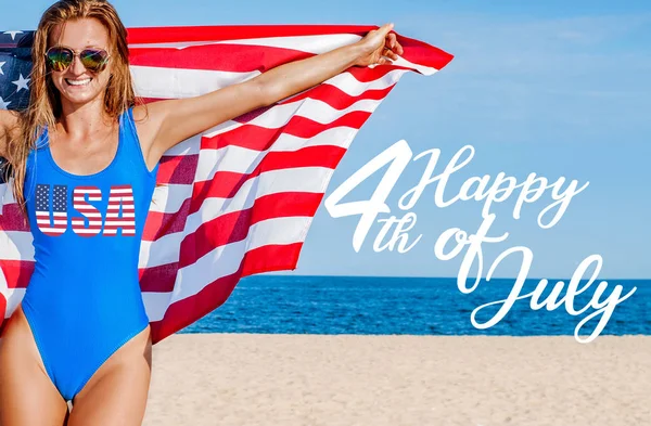 미국 독립 기념일. 미국은 7월 4일을 기념합니다. 해변에서 미국 국기를 들고 행복한 여자. — 스톡 사진