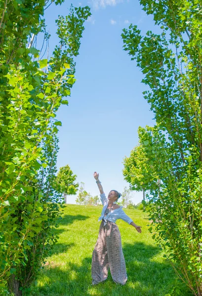 Frumoasa femeie în stil boho se plimbă pe iarbă și se bucură de timpul de vară în parc . — Fotografie, imagine de stoc