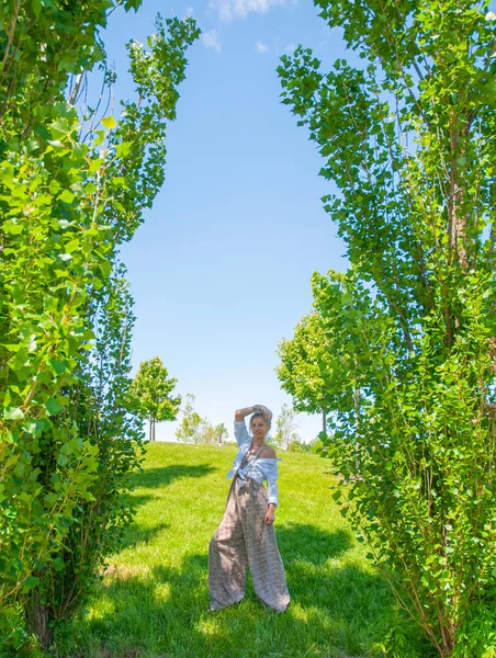 Frumoasa femeie în stil boho se plimbă pe iarbă și se bucură de timpul de vară în parc . — Fotografie, imagine de stoc