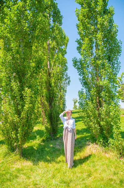Frumoasa femeie în stil boho se plimbă pe iarbă și se bucură de timpul de vară în parc . — Fotografie, imagine de stoc